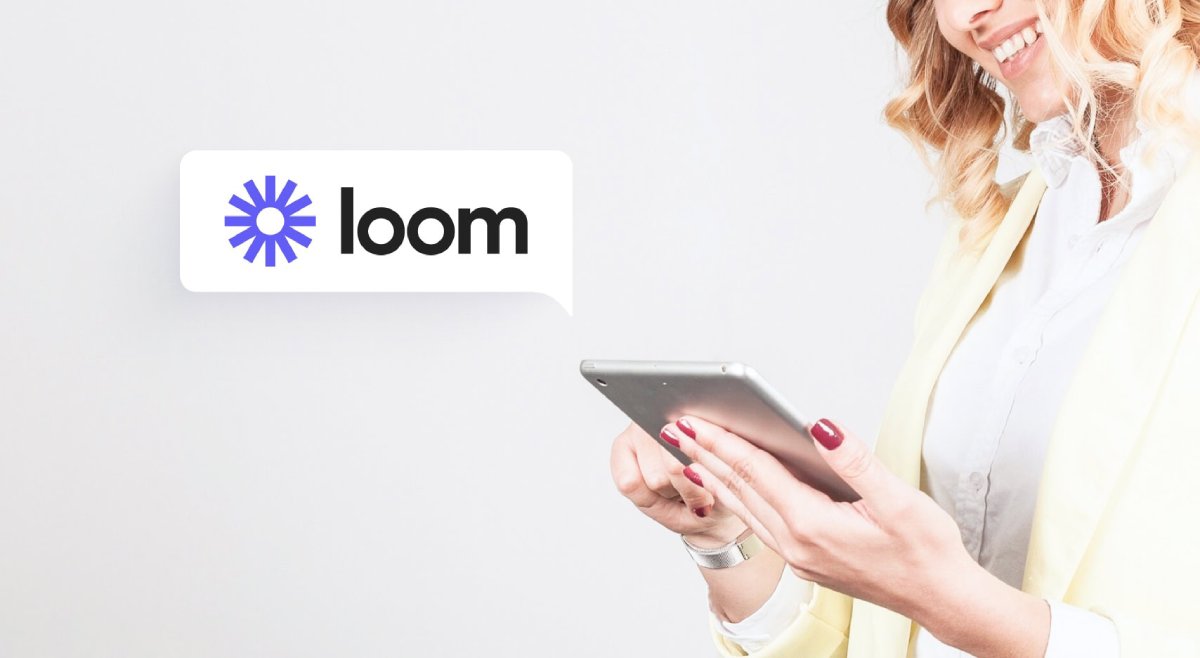 Smiling woman in yellow blazer using tablet with Loom logo appearing in a speech bubble.